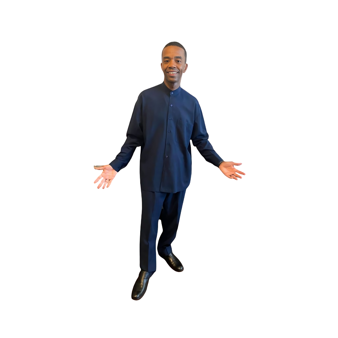 Aleem posing with open arms in a navy blue leisure suit by Kameelah's Closet, highlighting modest clothing inspired by the Nation of Islam.