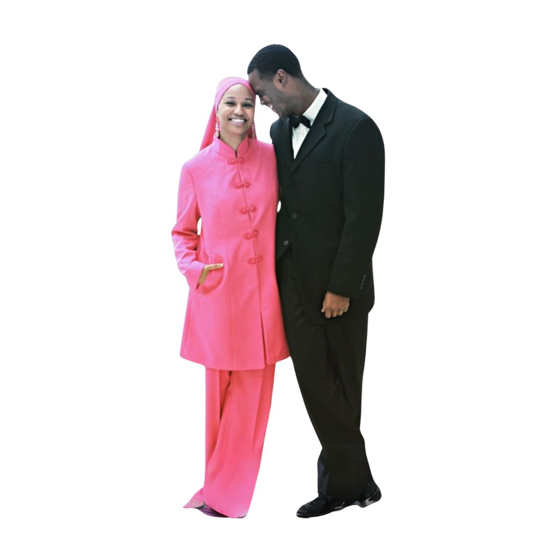 Full-body front view of a man in a black custom design suit and a woman in a pink three-piece garment, designed for Muslim brothers and sisters in the Nation of Islam who value modest clothing.