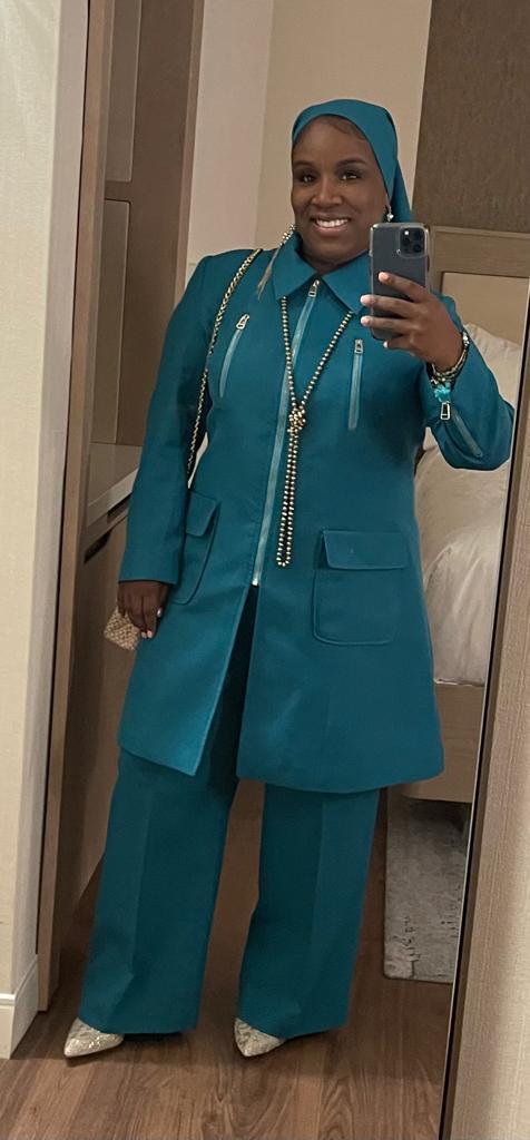 Full-body view of Rashidah modeling the Rashidah three-piece aqua blue garment from a tilted front and side angle, designed for Muslim sisters in the Nation of Islam who value women's modest clothing.