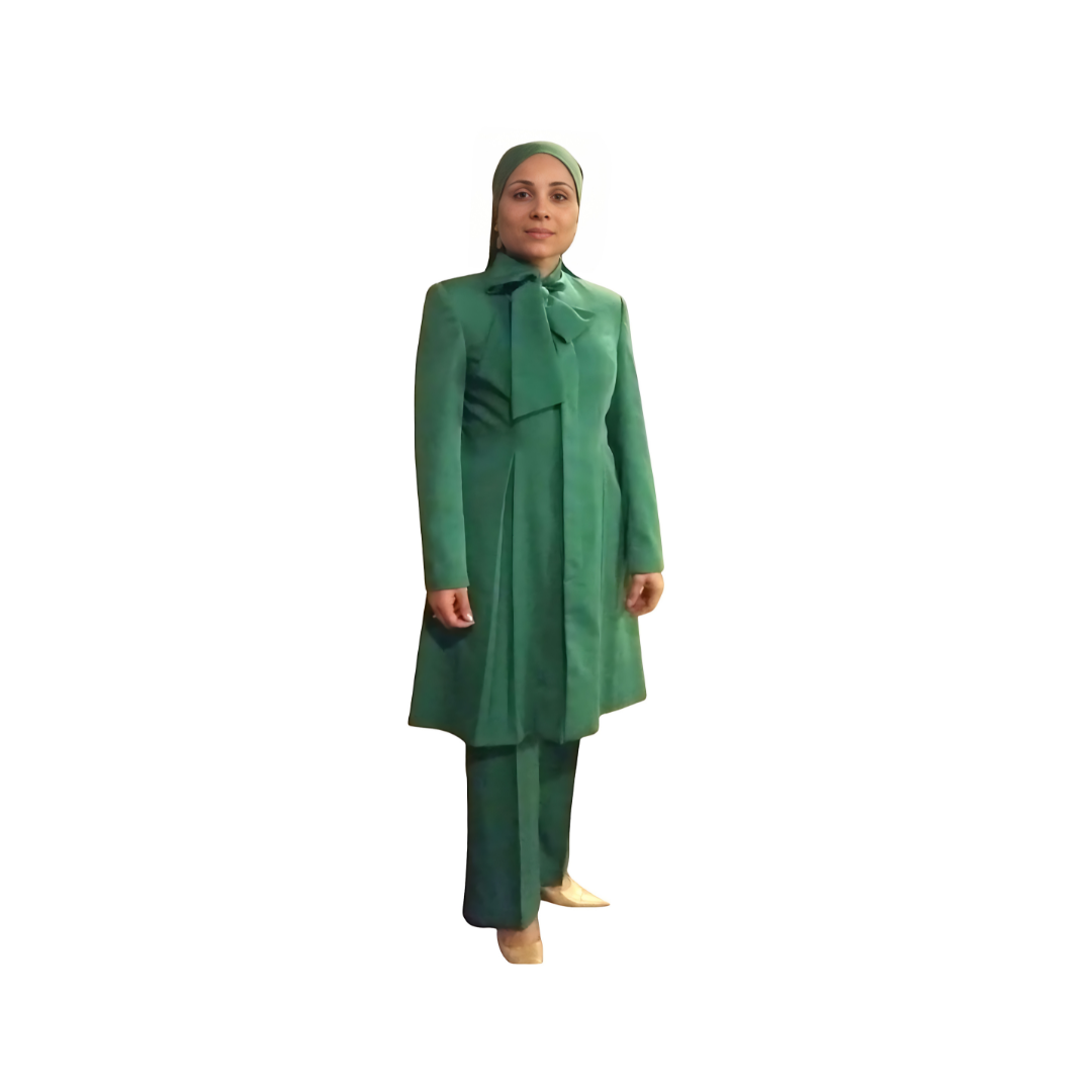 Full-body view of Sadiyah modeling the Sadiyah Bow three-piece green garment from a tilted front and side angle, designed for Muslim sisters in the Nation of Islam who value women's modest clothing.